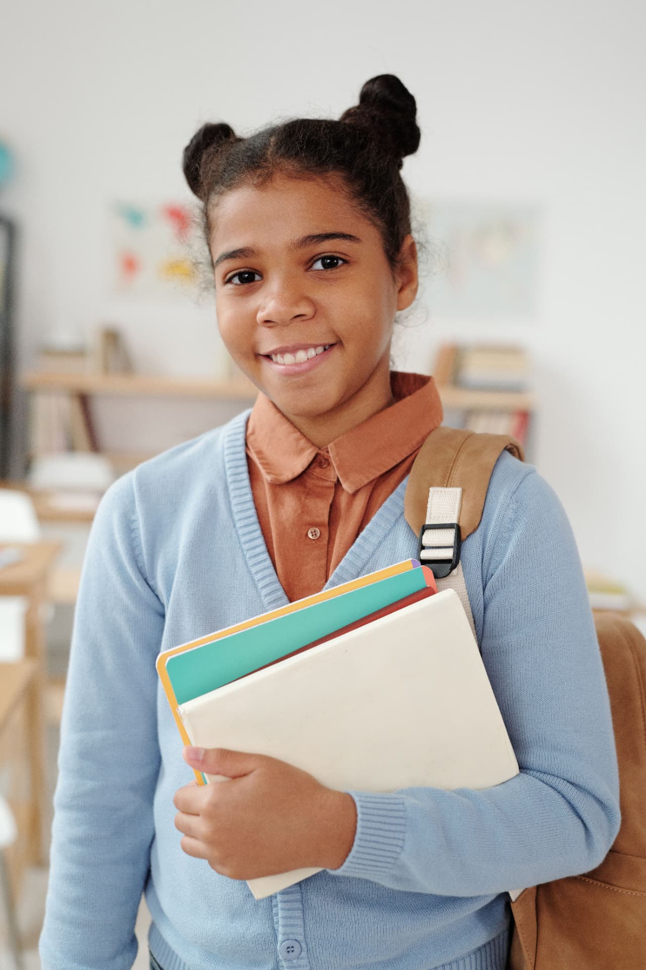 A smiling young student with books